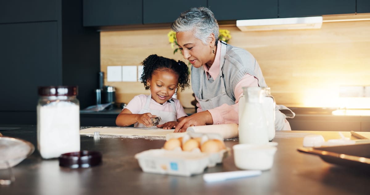 An older woman rolling pastry on a kitchen counter